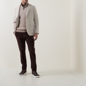 Model wearing Boglioli beige wool-cashmere blend jacket, styled with brown knitwear, dark trousers and dark trainers.