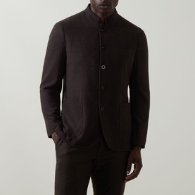 Model wearing Boglioli brown wool cashmere jacket with mandarin collar, three-button front, and patch pockets, styled with matching brown trousers.