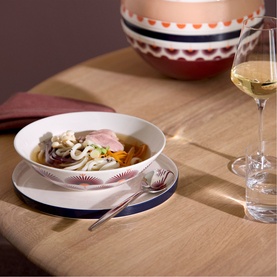 Villeroy & Boch Iconic La Boule Kyoto dinnerware set; pasta bowl on patterned plate, styled on wood table with decorative vase and wine glass.