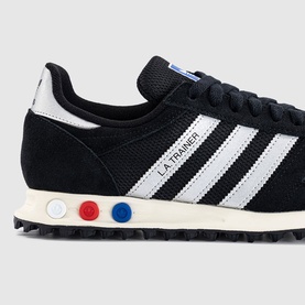 adidas LA Trainer sneaker in black with white three-stripe detail, red and blue midsole dots, and black rubber outsole