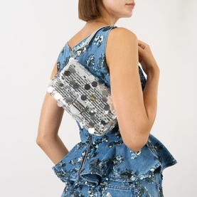 Model carrying Mario Valentino Sleet Sequin Crossbody Bag in grey with silver sequins and gold-tone hardware, worn crossbody over denim outfit