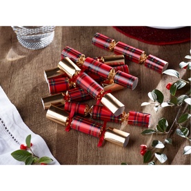 Set of red tartan and gold Christmas crackers arranged on a wooden surface with festive holly and ribbon styling