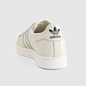 Adidas low-top leather trainer in off-white with carbon stripe detailing, white cupsole, and black heel tab with Trefoil logo