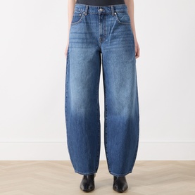 Model wearing Seven Jeans wide-leg barrel jeans in Skyfrost blue denim, high-rise waist, styled with black ankle boots