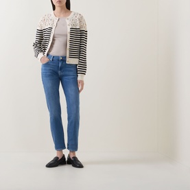 Model wearing Seven Jeans Coastline skinny jeans, styled with a striped lace-trim cardigan, grey top and black loafers.