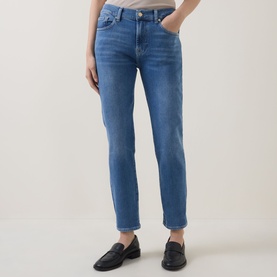 Model wearing Seven Jeans Skinny Jeans in Coastline blue denim, styled with black loafers and a neutral top.