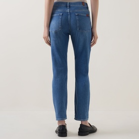 Model wearing Seven Jeans Skinny jeans in Coastline blue denim, rear view, styled with black loafers