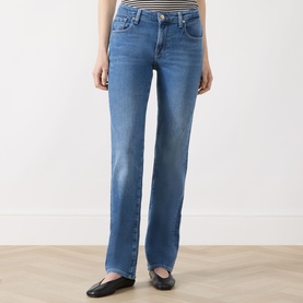 Model wearing Seven Jeans Slim jeans in Coastline blue denim, styled with a striped top and black ballet flats.