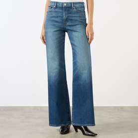Model wearing Seven Jeans Lotta Wide-Leg Jeans in Blue Core mid wash with tobacco stitching, styled with black heeled boots.
