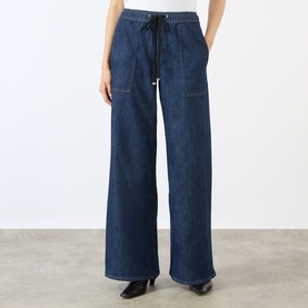 Model wearing Seven Jeans Wide Leg jeans in Halona dark blue denim, with drawstring waist and patch pockets, styled with black heeled mules.