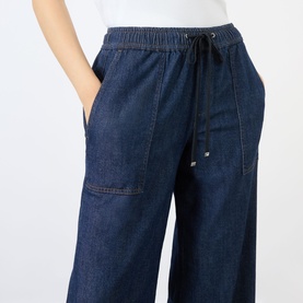 Model wearing Seven Jeans Wide Leg jeans in Halona dark indigo denim with elasticated drawstring waist and large patch pocket.