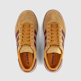 Adidas trainers in Preloved Yellow with burgundy three-stripe detailing, tan suede upper, gold eyelets, and cream gum sole, overhead view.