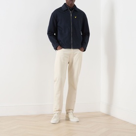 Model wearing Lyle & Scott Eagle Logo Overshirt in Dark Navy with zip fastening, styled with cream trousers and white trainers