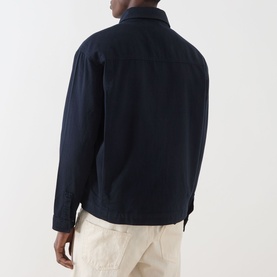 Model wearing Lyle & Scott Eagle Logo Overshirt in Dark Navy, back view, paired with light beige trousers.
