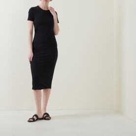 Model wearing Spanx dress in Classic Black, short-sleeve ribbed midi style, styled with brown leather flat sandals.