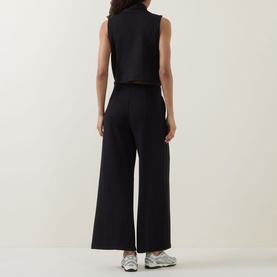 Model wearing Spanx AirEssentials&reg; Half-Zip Jumpsuit in Very Black, rear view, styled with silver trainers