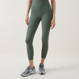Model wearing Spanx SPANXshape&trade; Booty Boost&reg; 7/8 Leggings in Eucalyptus, styled with grey trainers