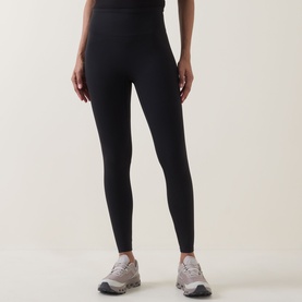 Model wearing black high-waist leggings, styled with grey and white trainers