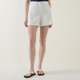 Model wearing Spanx SPANXsupersmooth&reg; EasyBreezy Shorts in Ivory, cotton-linen blend with double button fly and jet pockets, styled with black sandals