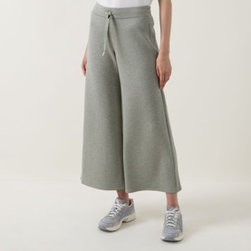 Model wearing Spanx AirEssentials Wide Leg Track Pants Petite in Sage Heather, wide-cut cropped silhouette with drawstring waist, styled with grey