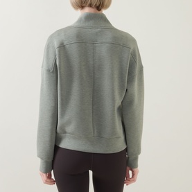 Model wearing Spanx AirEssentials&reg; Half-Zip Sweatshirt in Sage Heather, back view showing seam details and dropped shoulders, styled with dark