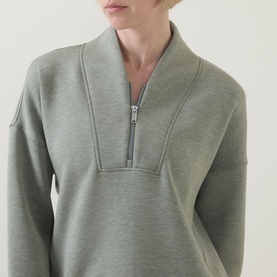 Model wearing Spanx AirEssentials&reg; Half-Zip Sweatshirt in Sage Heather, showing shawl collar, half-zip fastening and seam details at neckline.