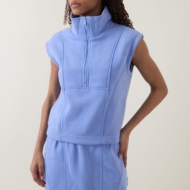 Model wearing Spanx BoostUp Half-Zip Sweatshirt in Hyacinth, sleeveless with funnel neck and seam details, styled with matching sweatpants
