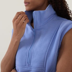 Model wearing Spanx BoostUp Half-Zip Sweatshirt in Hyacinth with funnel neck, cap sleeves, and half-zip fastening, close-up detail view