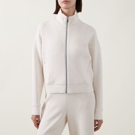 Model wearing Spanx AirEssentials&reg; Track Jacket in Oatmeal Heather, zip-front, high neck, ribbed trims, styled with matching trousers.