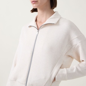 Model wearing Spanx AirEssentials&reg; Track Jacket in Oatmeal Heather, featuring zip fastening, high neckline and ribbed trims.