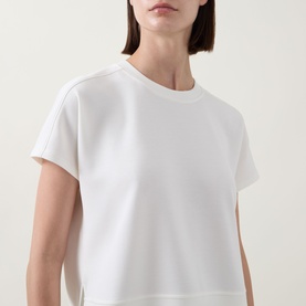 Model wearing Spanx AirEssentials T-Shirt in Powder, round neckline, short sleeves, relaxed fit cropped view