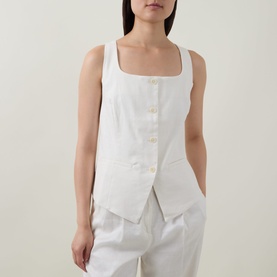 Model wearing Spanx Ivory top with square neckline, button front, and asymmetric hem, styled with white wide-leg trousers.