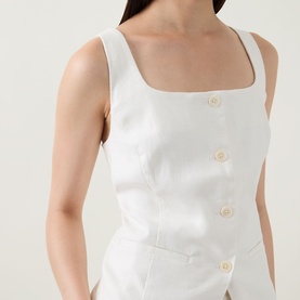 Model wearing Spanx ivory square-neck top with gold button detail front fastening, fitted silhouette in cotton-linen blend fabric