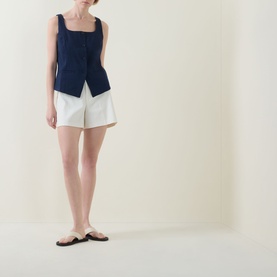 Model wearing Spanx top in Timeless Navy with square neckline, styled with white shorts and brown flat sandals