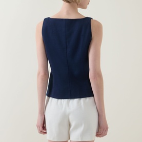Model wearing Spanx top in Timeless Navy, back view, sleeveless with boat neck and centre back seam detail, styled with white shorts.