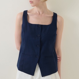 Model wearing Spanx top in Timeless Navy, square neckline, button-front fastening and patch pockets, styled with white trousers