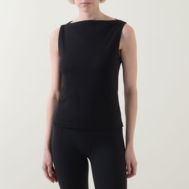 Model wearing Spanx Classic Black sleeveless top with boat neckline, styled with matching black trousers.