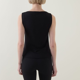 Model wearing Spanx Classic Black sleeveless top, back view, with black leggings.