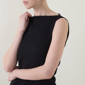 Model wearing Spanx Classic Black sleeveless top with boat neckline, cropped view showing structured fit