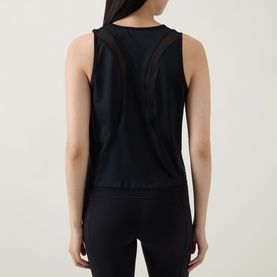Model wearing Spanx Sheeriours Panel Performance Top in Very Black, rear view showing sheer mesh panel details, paired with black leggings