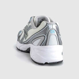 New Balance trainer in white and castlerock metallic, rear view showing chunky white sole, mesh upper and silver overlays