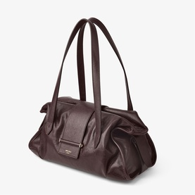Dark chocolate brown leather shoulder bag with dual top handles, gold-tone logo plaque, and structured base on white background