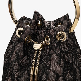 Black lace bucket bag with gold ring handle, chain drawstring tassels, and nude lining visible beneath floral lace overlay