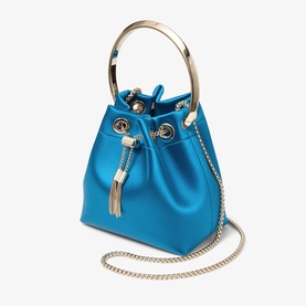 Jimmy Choo bucket bag in lagoon blue satin with light gold ring handle, tassel drawstring detail, and gold chain crossbody strap