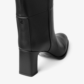 Black leather knee-high boot with block heel, tonal logo emblem at shaft, and pull-on tab detail