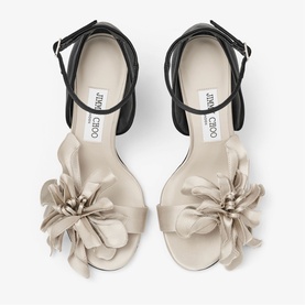 Jimmy Choo white satin sandals with oversized floral embellishment, black ankle strap, and block heel, top-down view