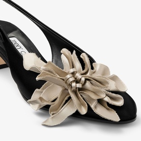 Jimmy Choo Eyla 45 Floral Slingback Block Heels in black satin, close-up of handcrafted layered champagne floral accent at toe