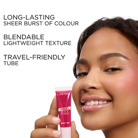 Model with Lanc&ocirc;me Blush in 00 Peach n Roses, holding pink tube; text highlights long-lasting, blendable, travel-friendly formula