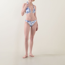 Model wearing Naia Beach Elba La Mer Print Bikini Briefs in blue floral print, low-rise with wide side panels, styled with matching triangle bikini