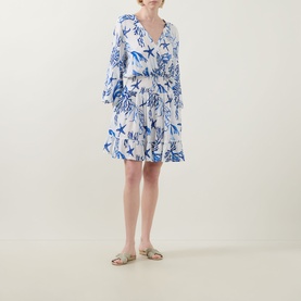 Model wearing Naia Beach Celia La Mer Print Kaftan in La Mer blue print, wrap front, flared sleeves, shirred waist, with gold flat sandals